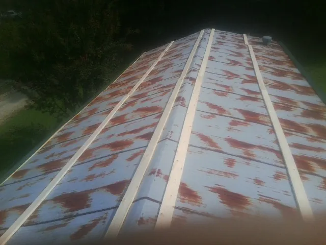 Rusted metal roof panels with new wood purlins before replacement — Storm Damage Roof Repair in Forman by Roofing Brothers