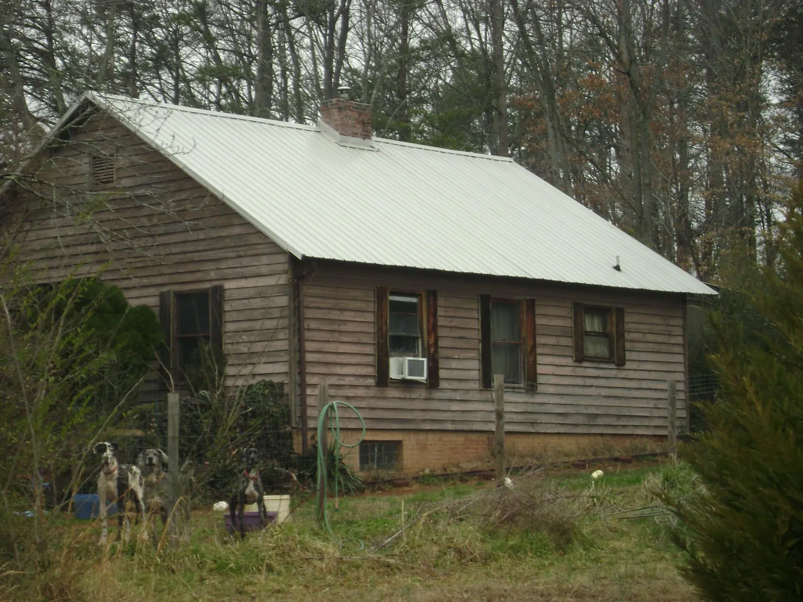 White metal roof on an old wood sided farmhouse, from a Metal Roof Installation job in Forman